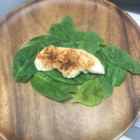 Cooked chicken on spinach leafs